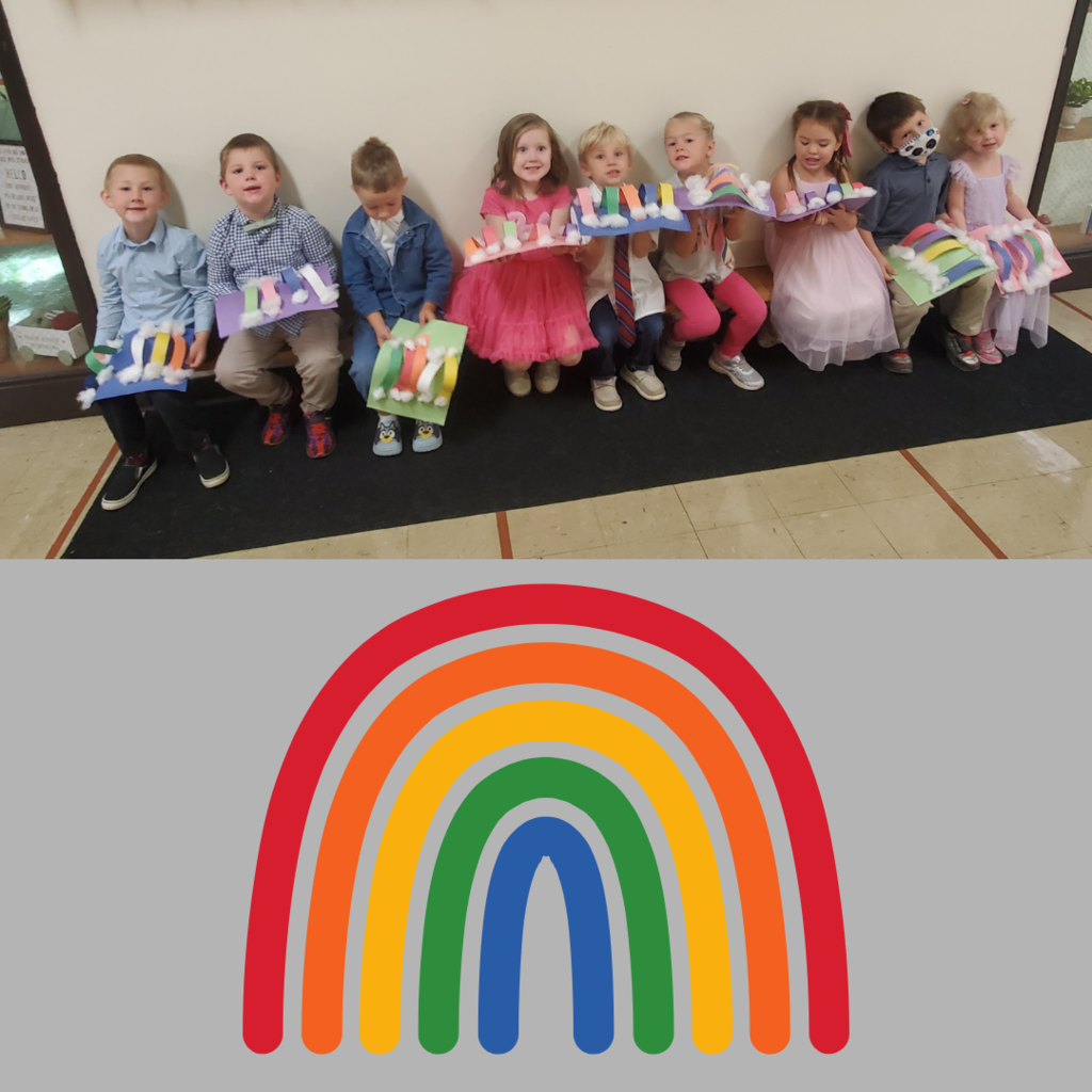 Preschool students posing with homemade rainbows