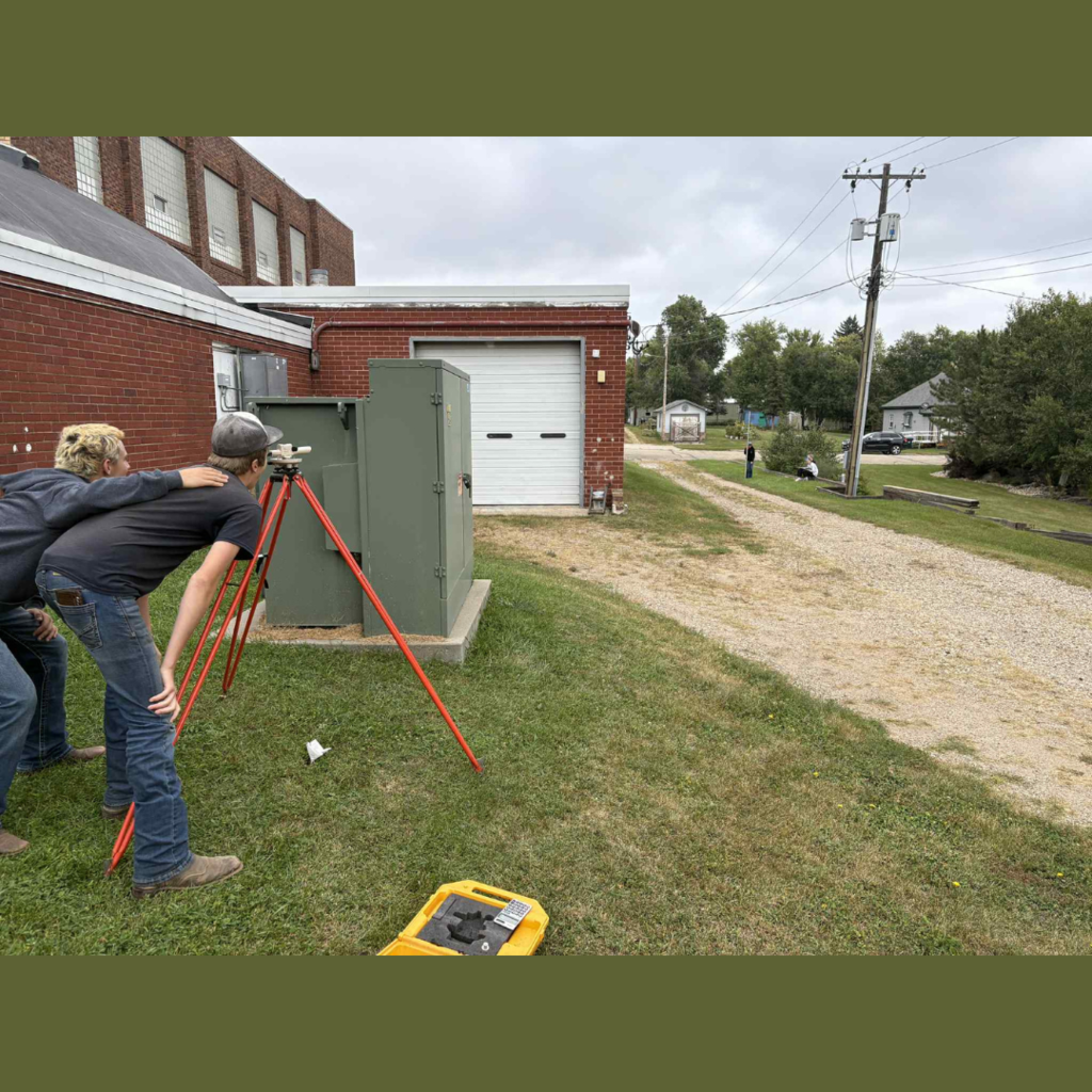 High school students using surveying equipment