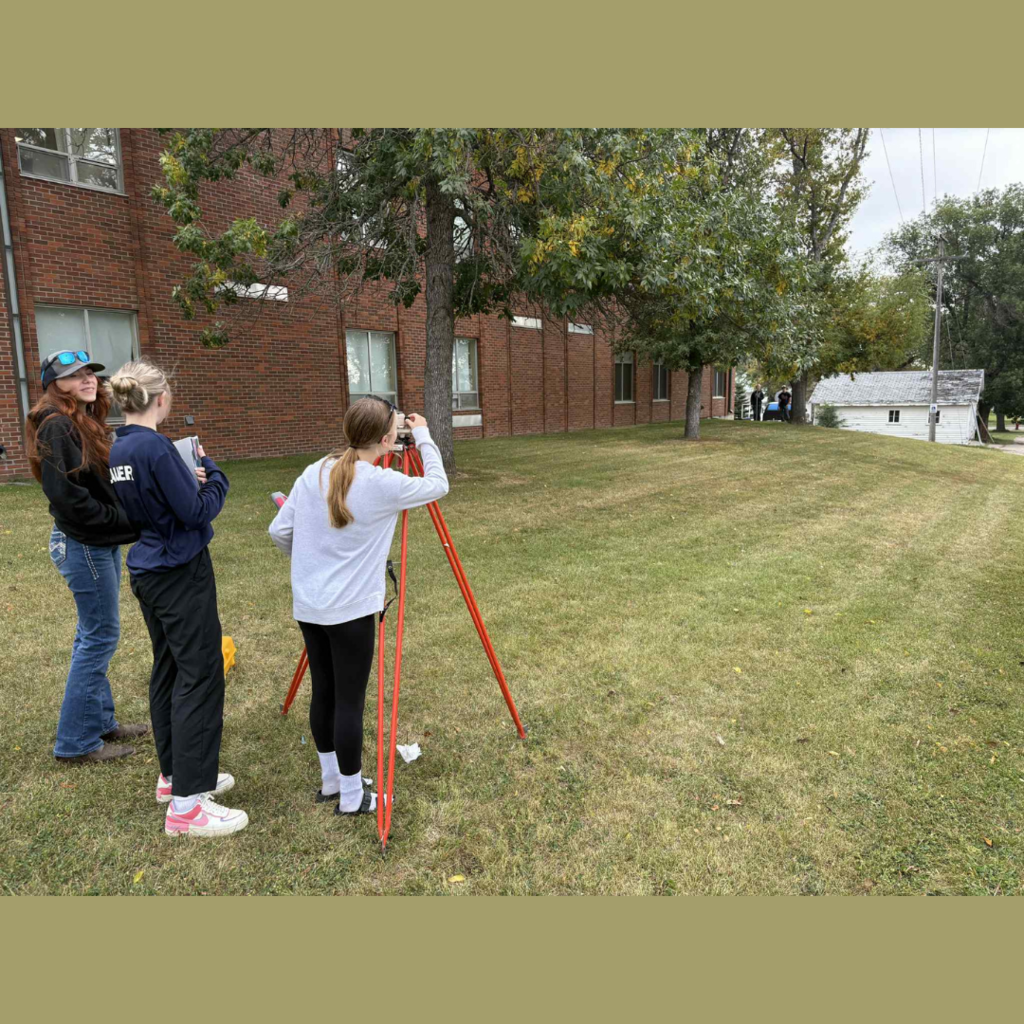 High school students using surveying equipment
