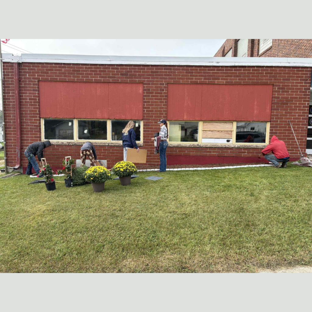 High school students landscaping in front of a school