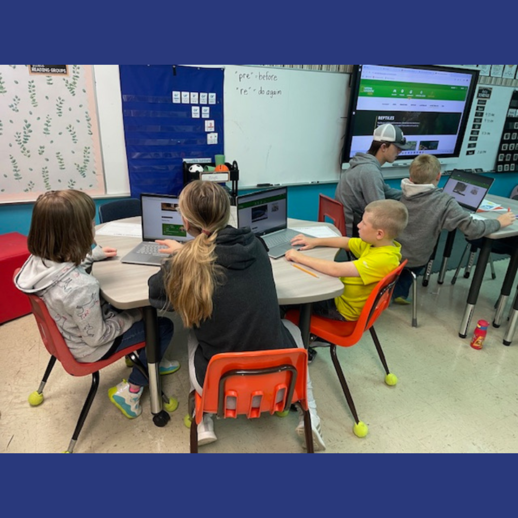High school and elementary school students working together using laptops to conduct research