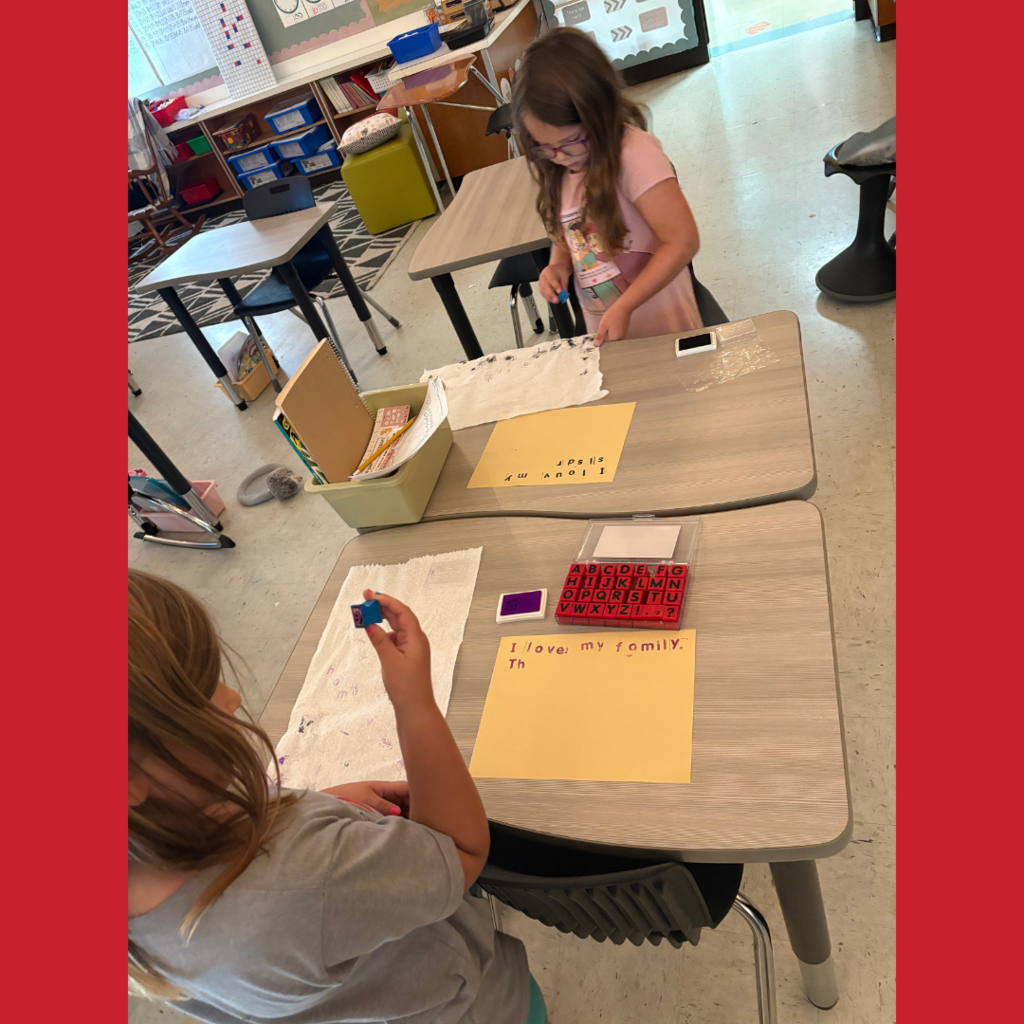 Lower elementary students using letter stamps on paper to write stories