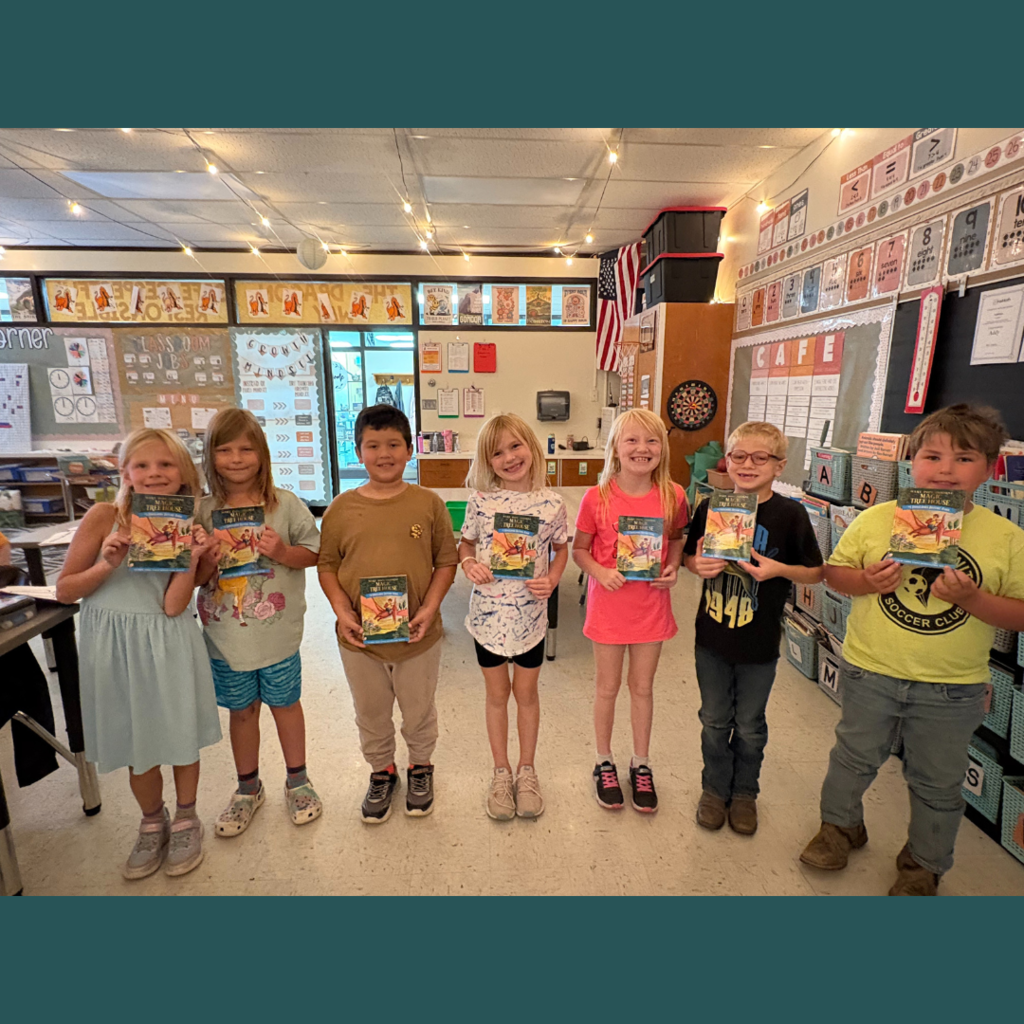 Lower elementary students posing with Magic Tree House books.