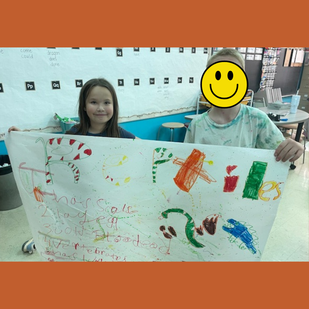 Elementary students posing with a large handmade poster