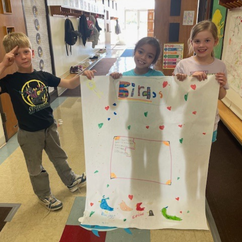 Elementary students posing with a large handmade poster