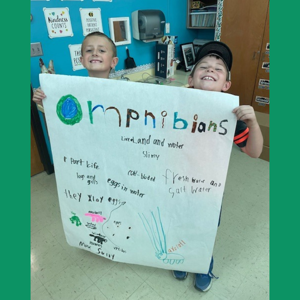 Elementary students posing with a large handmade poster