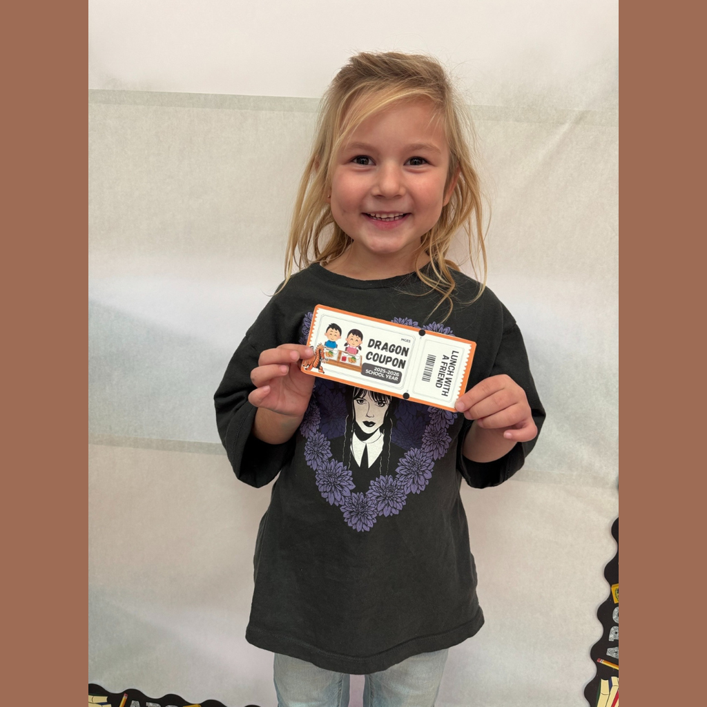 An elementary girl holding a paper coupon for lunch with a friend