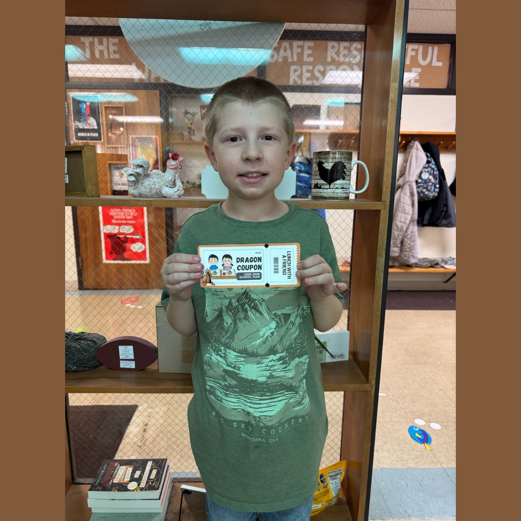 An elementary boy holding a paper coupon for lunch with a friend
