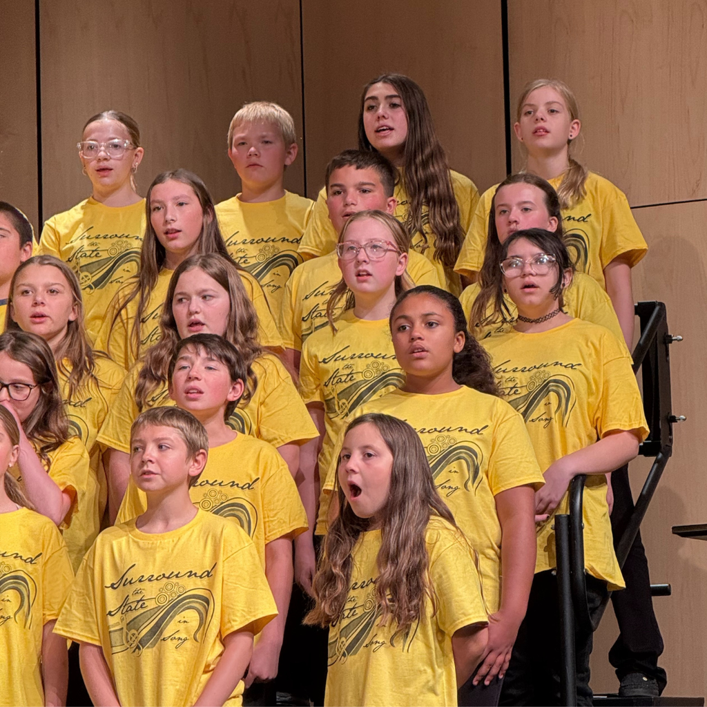 Junior high students standing on risers and singing