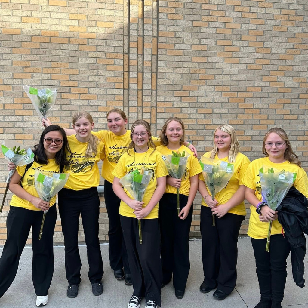 Six junior high girls holding roses and posing with their music teacher