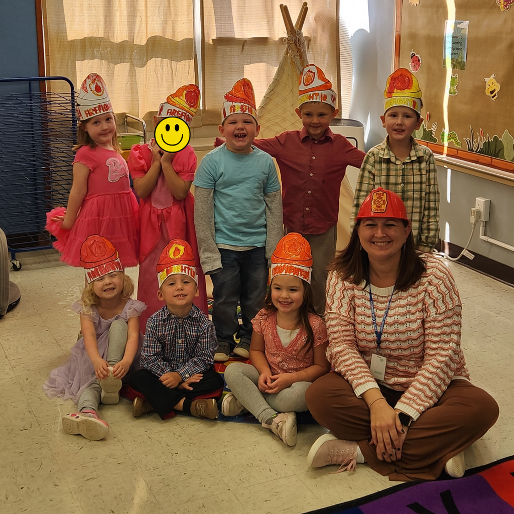 Preschool students and their teacher with firefighter hats