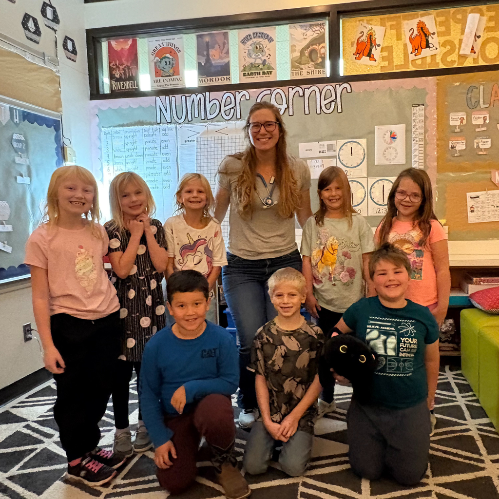 Lower elementary students posing with a nurse