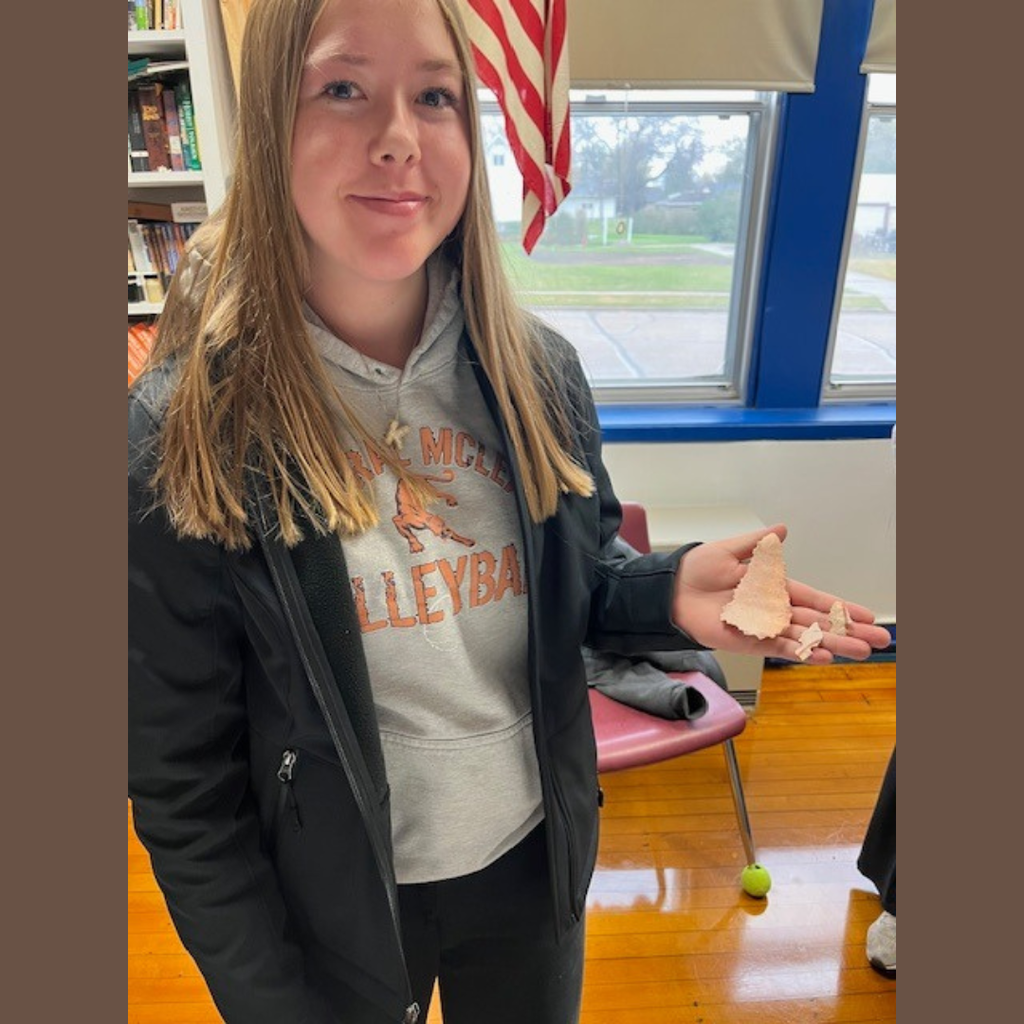 A high school girl showing off her flint knapping skills.