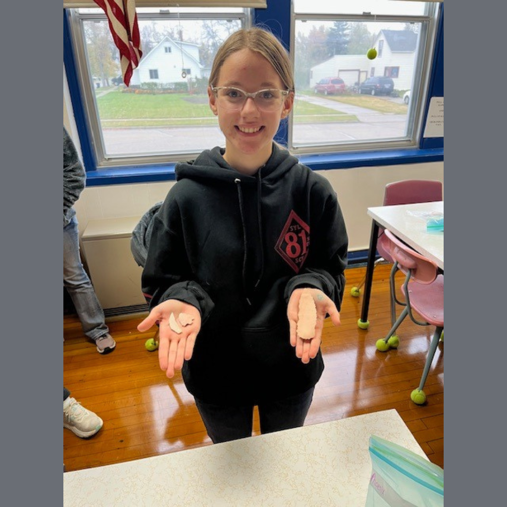 A high school girl showing off her flint knapping skills.