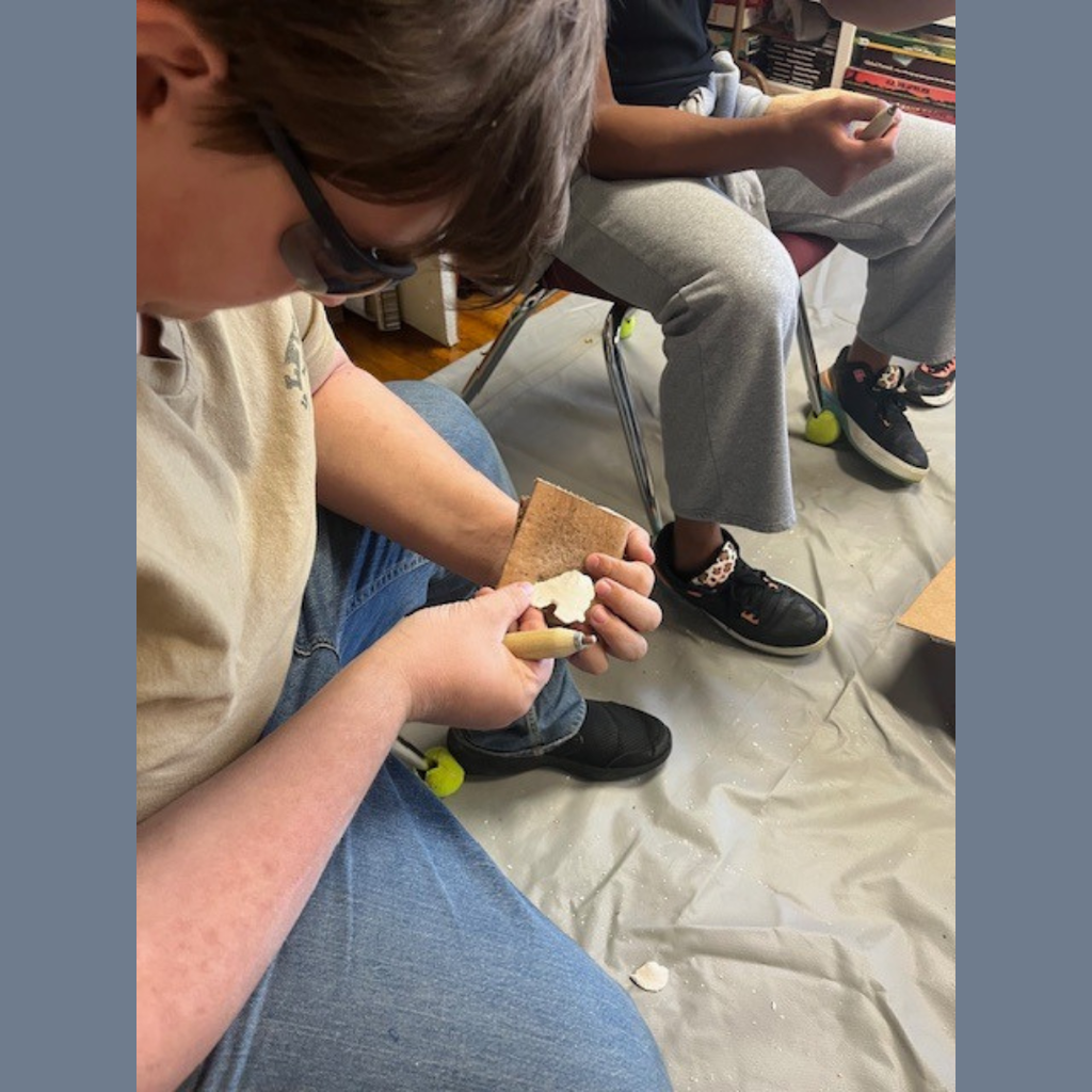 A high school student flint knapping.
