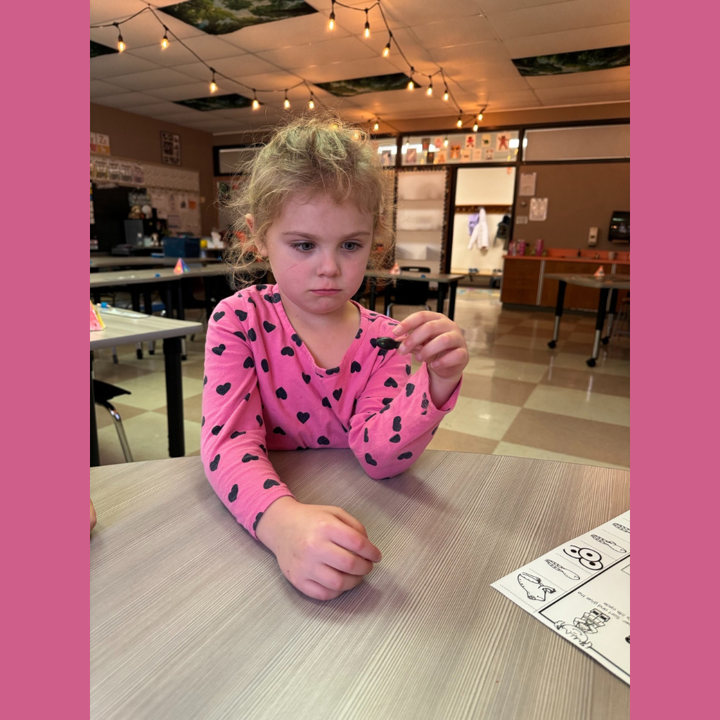 Kindergarten student looking at a plastic frog