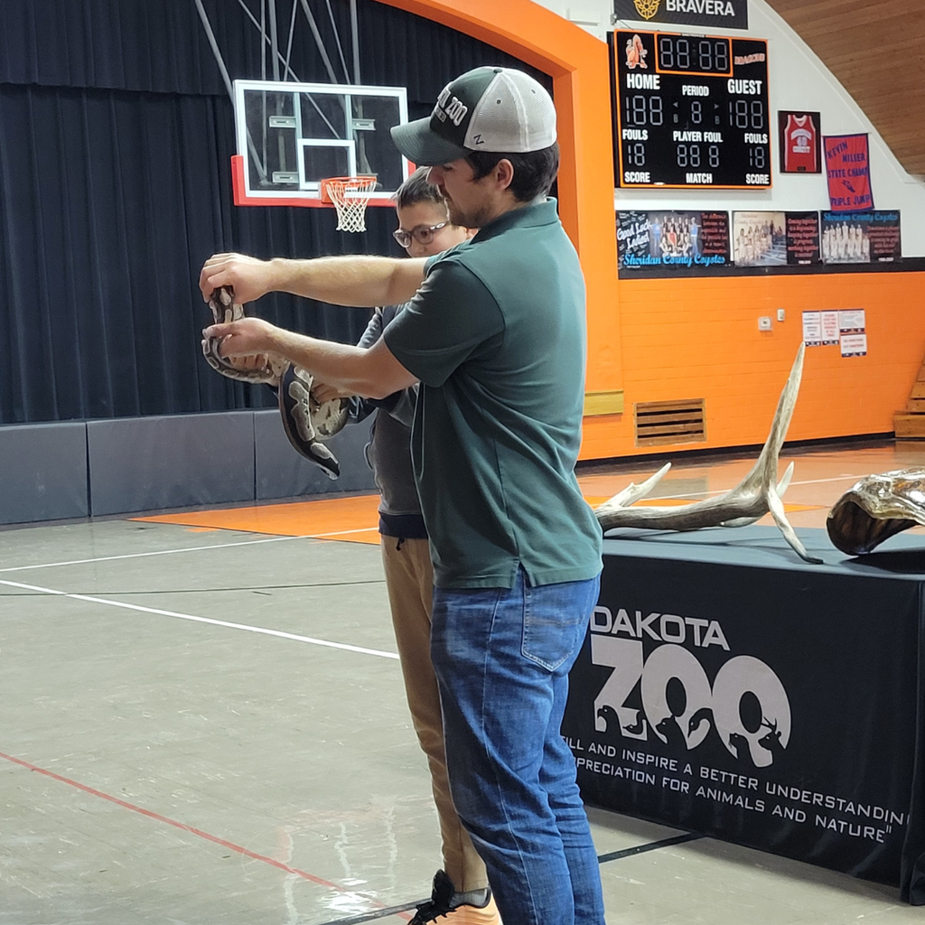 A man helping a high school student hold the python