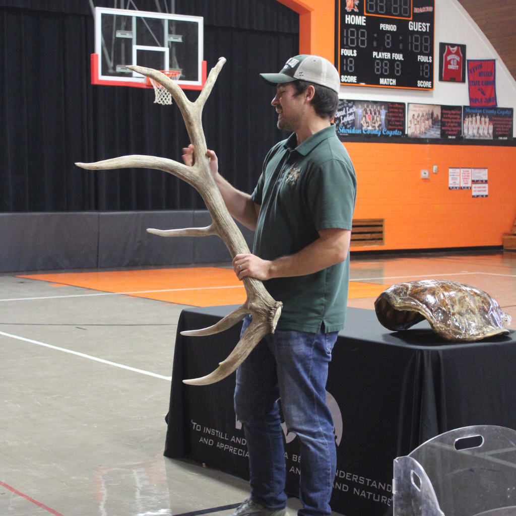 A man holding a large antler