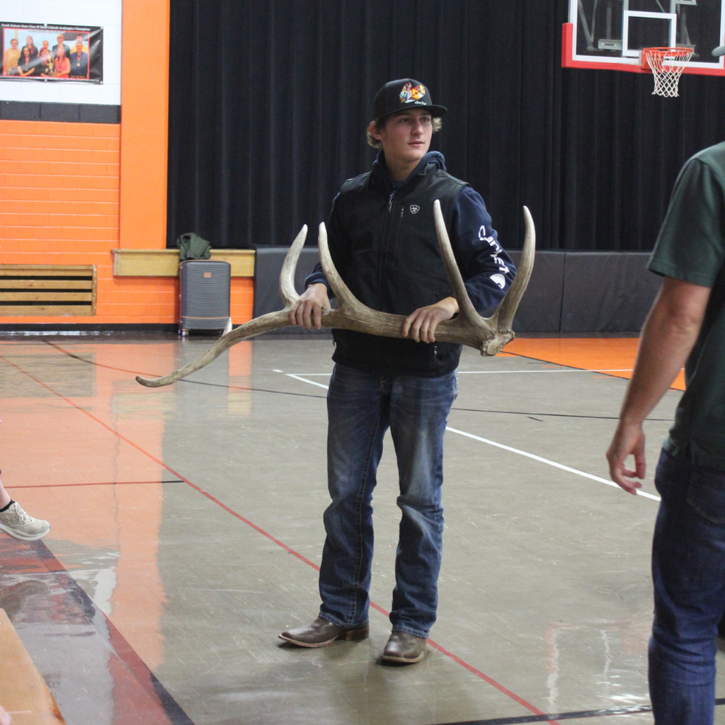 A high school student holding a large antler