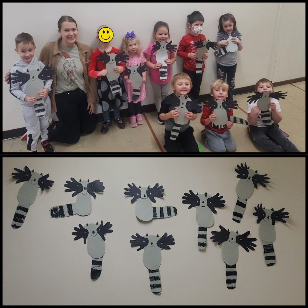 Preschool students posing with their paper raccoon crafts