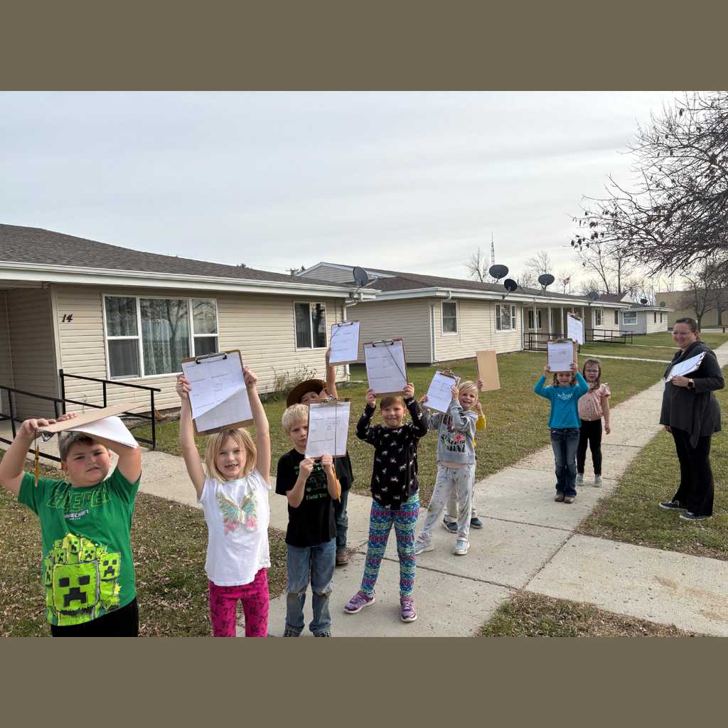 Lower elementary students showing their clipboards