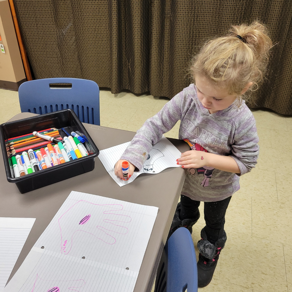 An elementary student making hand turkeys