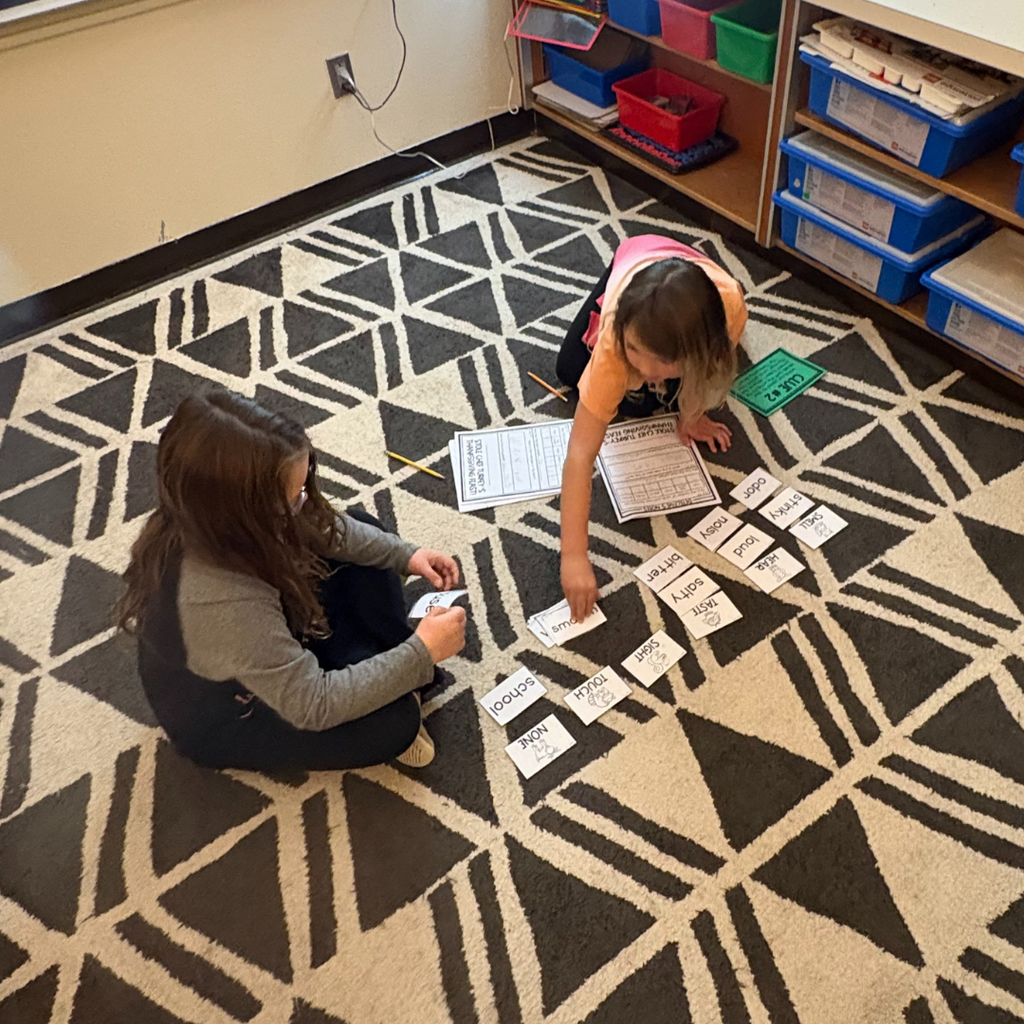 Elementary students writing on pieces of paper