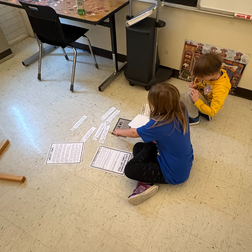 Elementary students writing on pieces of paper