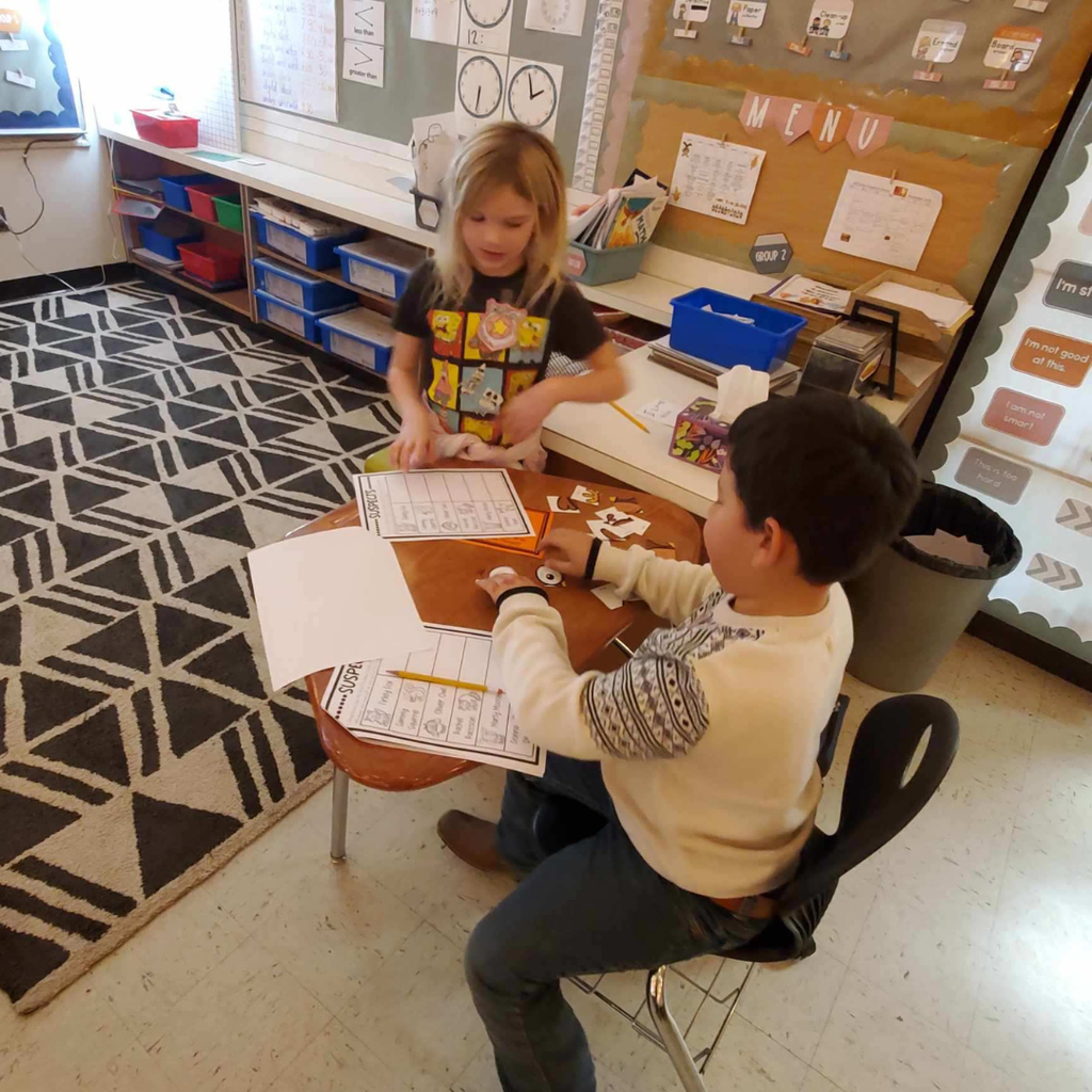 Elementary students writing on pieces of paper