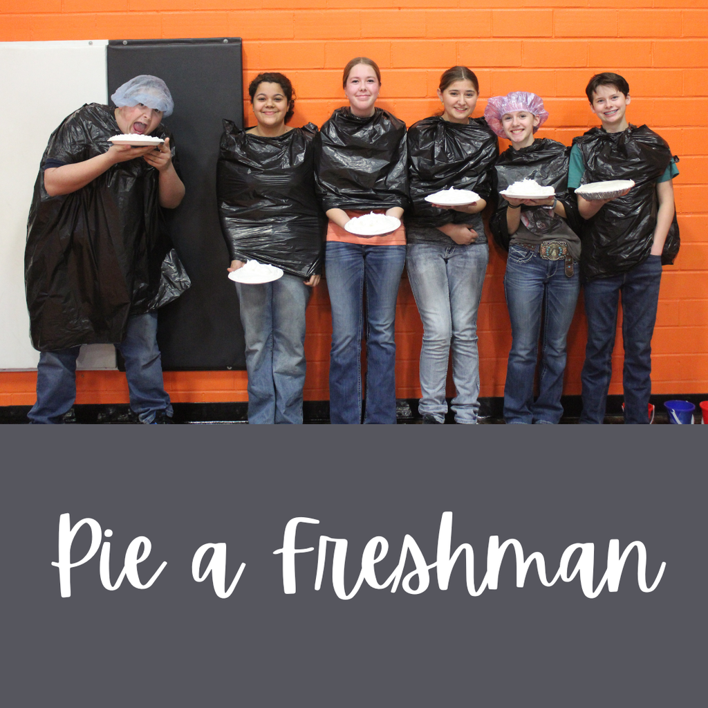 Six high school students posing with plates of whipped cream