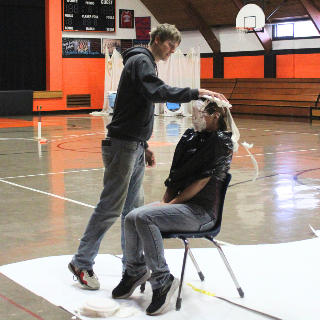 A high school student pieing another in the face