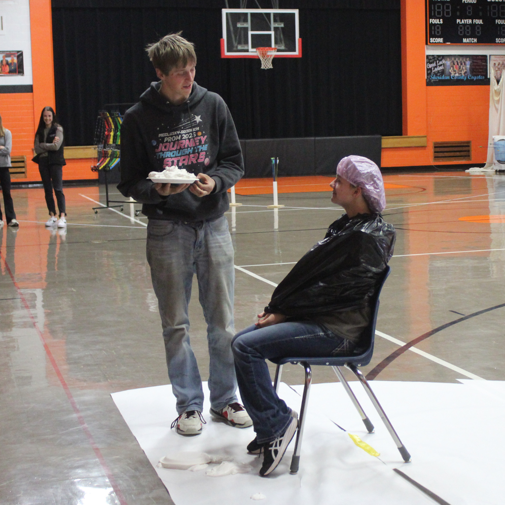 A high school student getting ready to pie another in the face