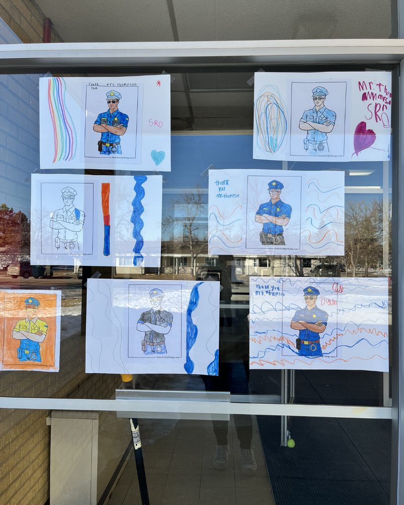 Hand-drawn pictures celebrating the school resource officer taped to the outside windows of the school.