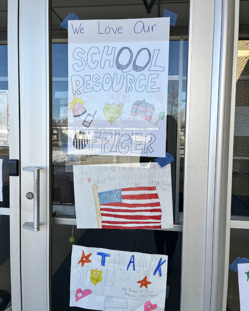 Hand-drawn pictures celebrating the school resource officer taped to the outside windows of the school.