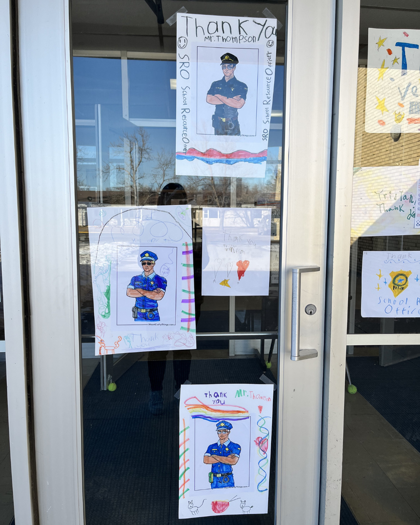 Hand-drawn pictures celebrating the school resource officer taped to the outside windows of the school.