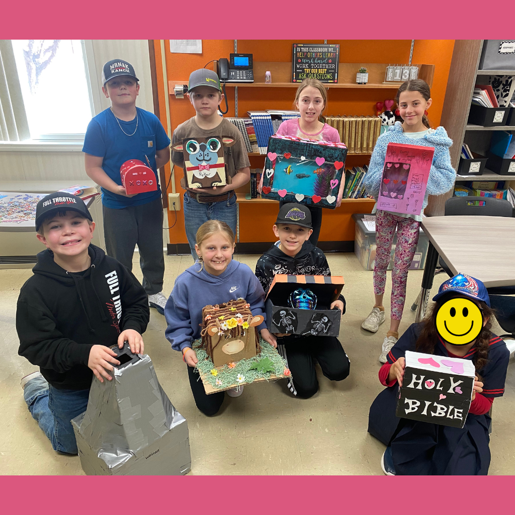 Upper elementary students posing with their homemade Valentine's Day boxes