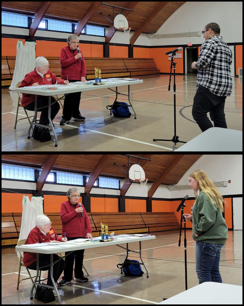 Junior high students speaking into a microphone in front of two women at a table