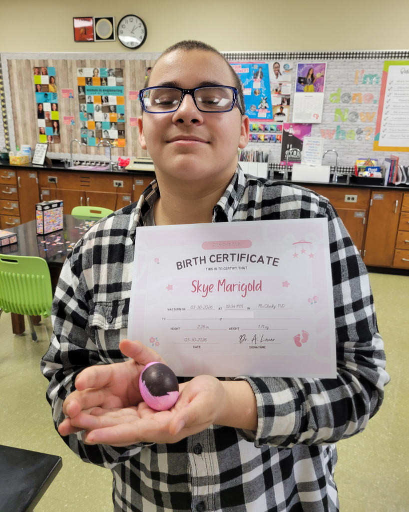 A junior high student holding an egg and a birth certificate