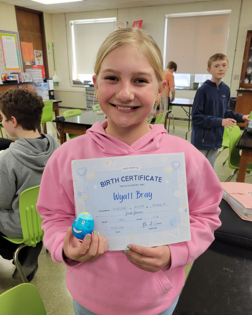 A junior high student holding an egg and a birth certificate