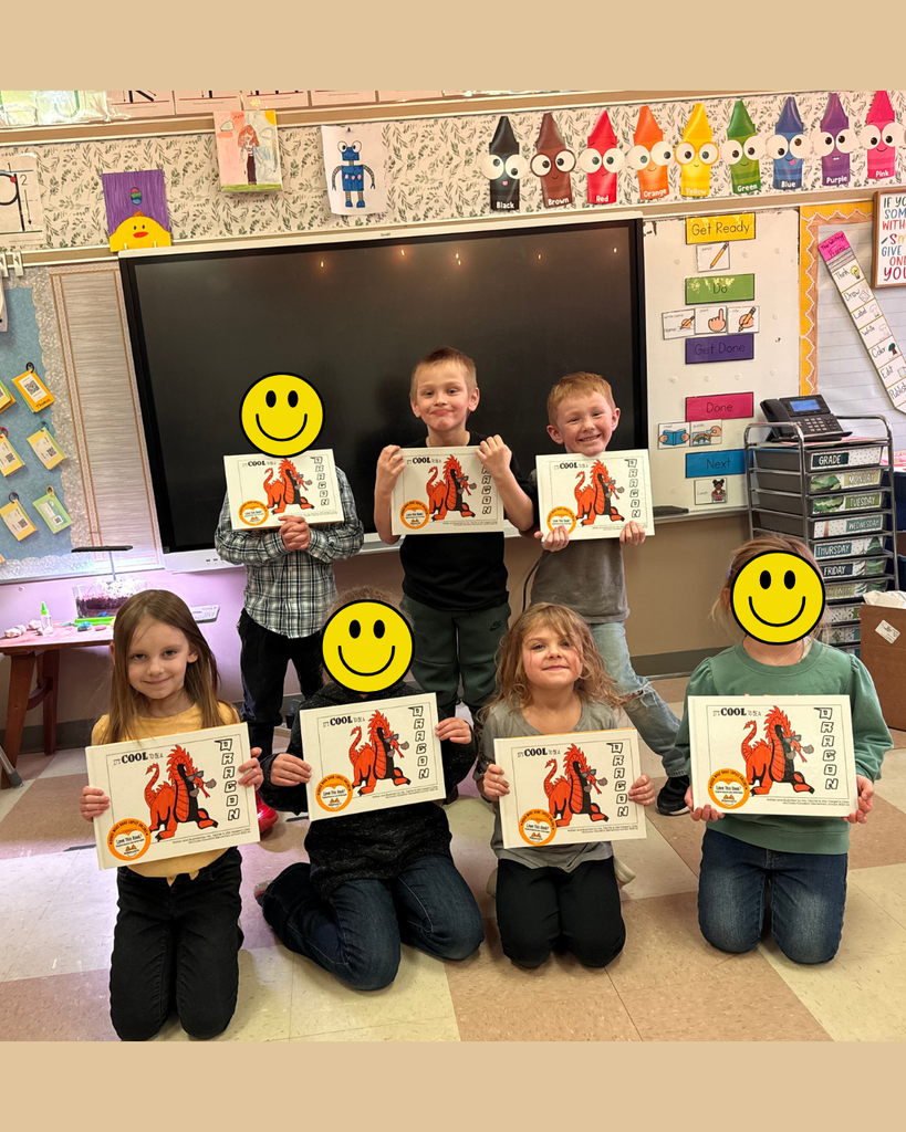 Young elementary students posing with their own copies of their published book.