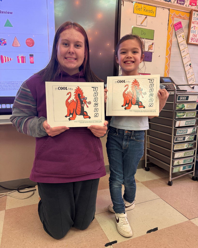 A high school student posing with a young elementary student and their book copies.