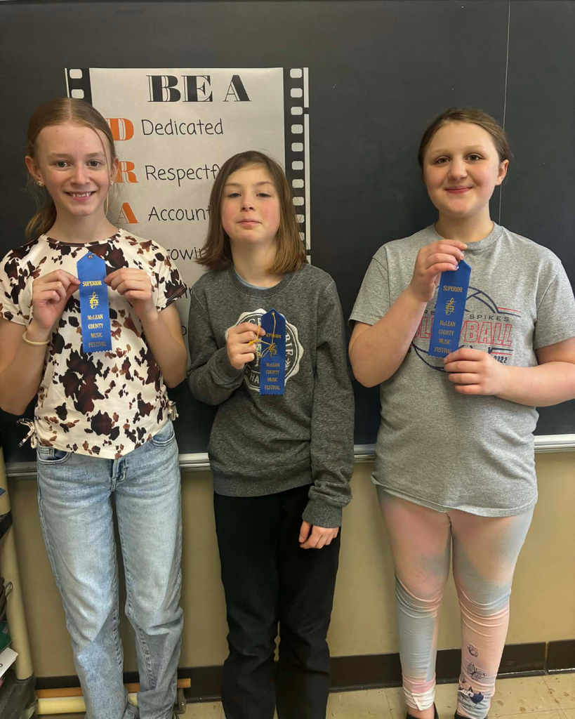 Three upper elementary students posing with blue ribbons