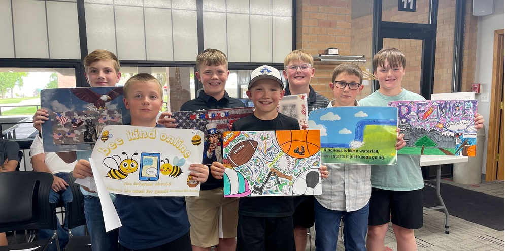 Photo of 5th Grade Dig Cit Poster Contest Winners and their art at the School Board Meeting on May 11: Ashton Koeppe, Lincoln Brown, Anson Schilling, Lynkyn Hagan, Elijah Scherbarth,  Brantley Peterson and Cooper Davidson.