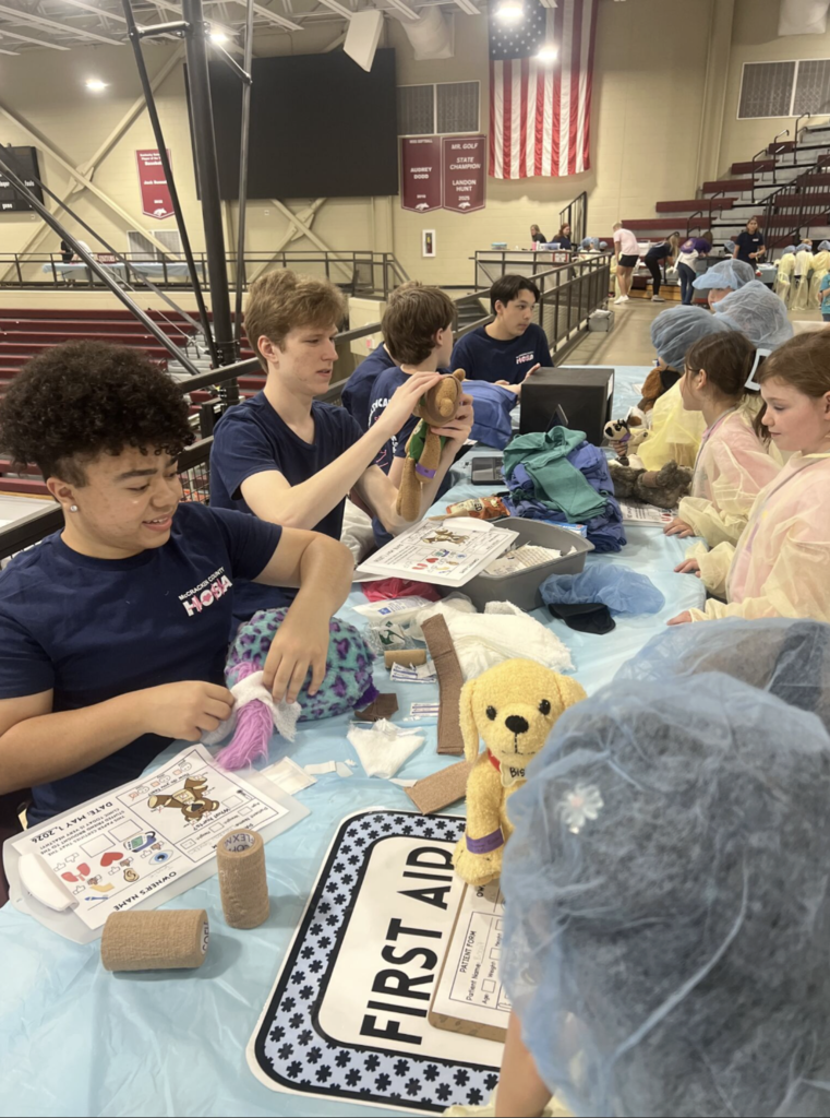 McCracken County High School HOSA (Future Health Professionals) chapter recently hosted a Teddy Bear Clinic for special guests from Heath Elementary School and Lone Oak Elementary School! The Teddy Bear Clinic was designed to help young students feel more comfortable with doctor visits while introducing them to exciting healthcare careers! Guided by our HOSA students, children brought stuffed animals for mock checkups and rotated through hands-on stations covering hygiene, first aid, medication safety, and more. It was a fun, interactive experience that inspired future healthcare professionals while easing fears about medical visits!