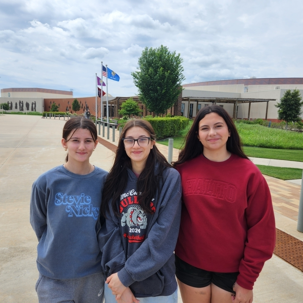 Photo of three students with the Choctaw Cultural Center in the background. 