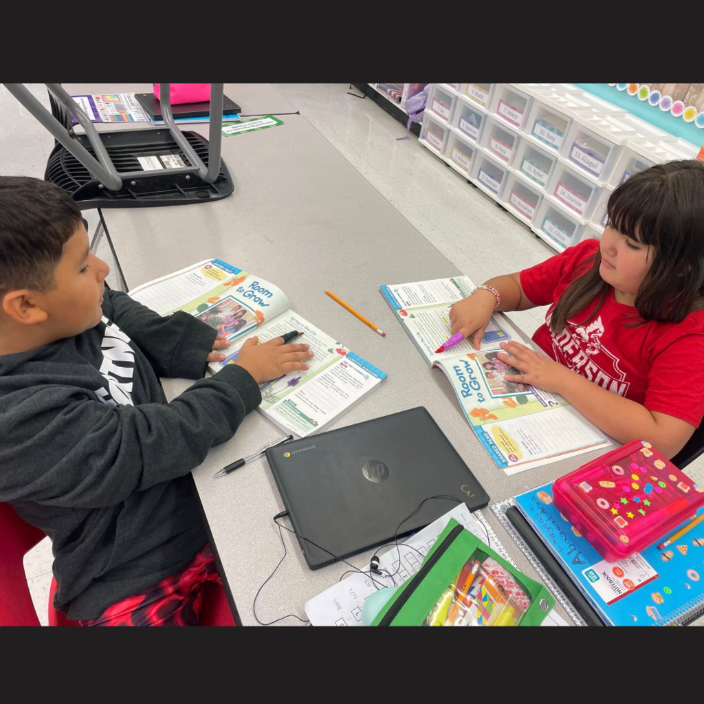 Two kids using Halloween fingers to read