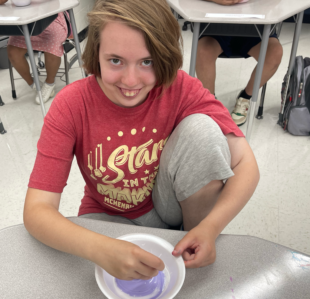 Student smiling and mixing slime 