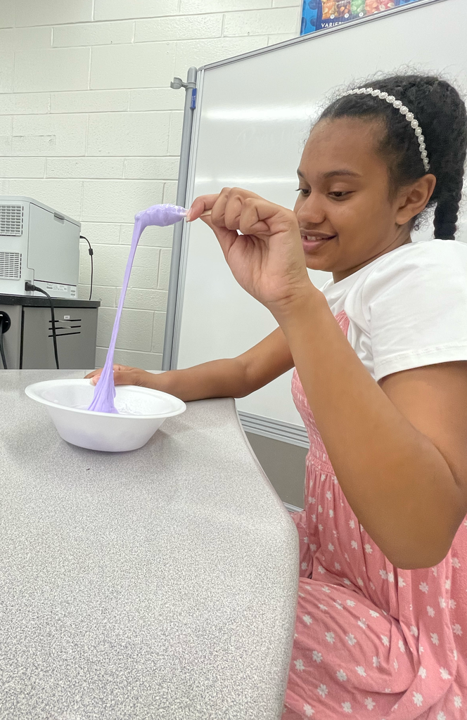 Student pulling slime with a popsicle stick