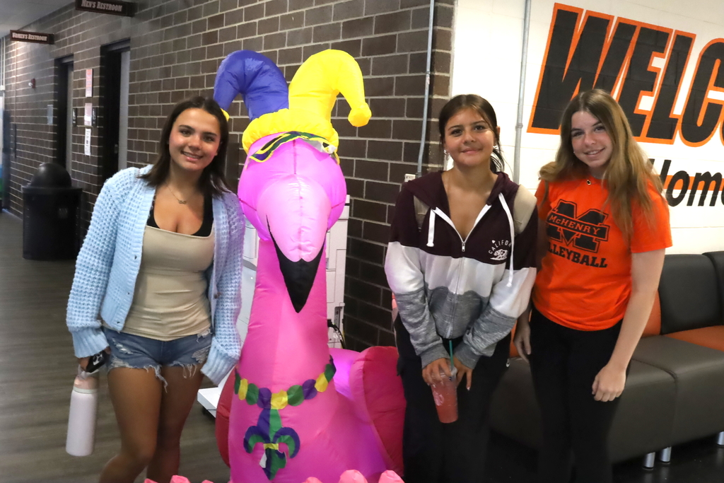 Three students with an inflatable pink flamingo 