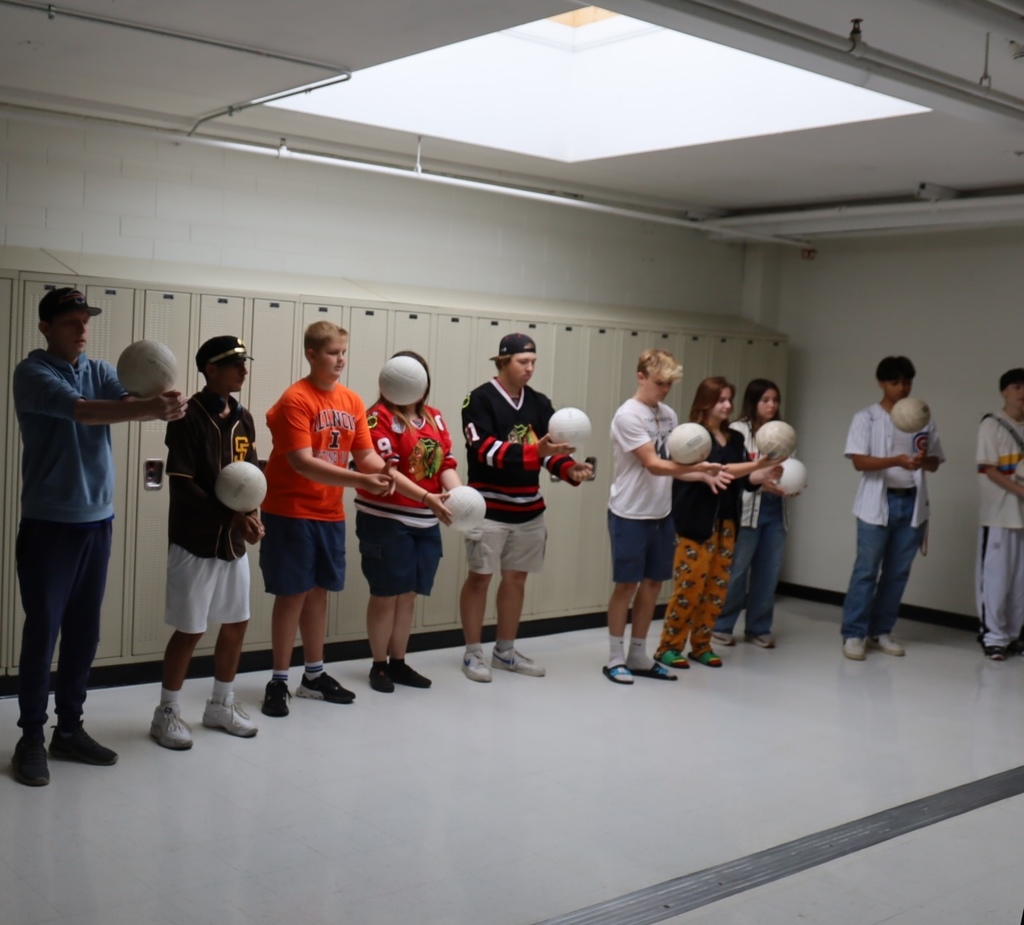 Students lined up in the hallway ready to play with the volleyballs 